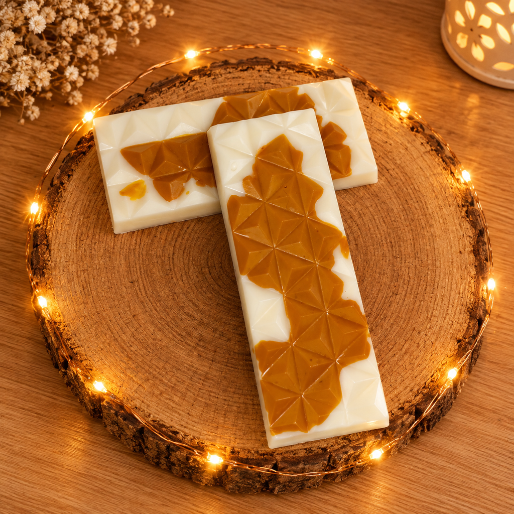 Deux tablettes de fondant Caramel Beurre Salé blanches et couleur caramel, croisées sur un rondin et photographiées du dessus.