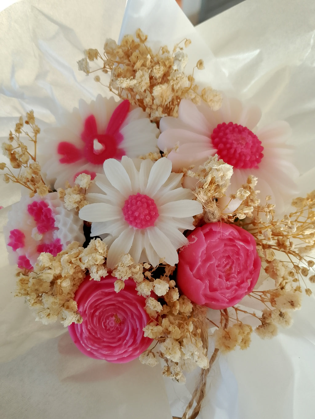« Bouquet de bougies en cire rose en forme de fleurs – roses, renoncules, marguerite et gypsophile séchée, emballé dans du papier de soie blanc »